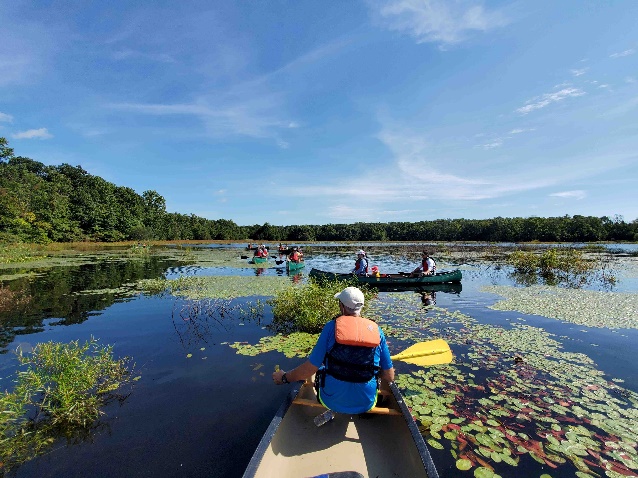 A group of people in canoes on a lake

Description automatically generated