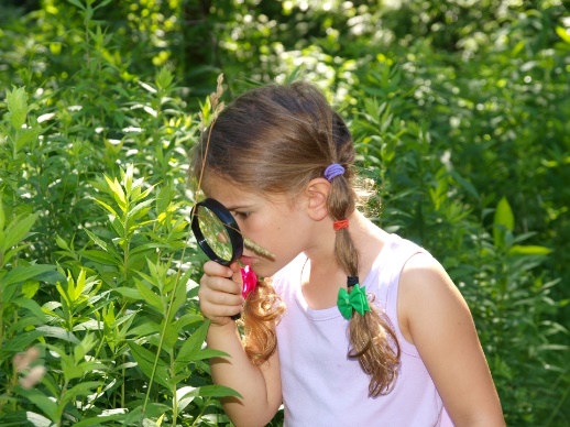 A child looking through a magnifying glass

Description automatically generated