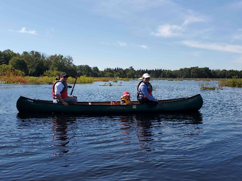 A group of people in a canoe on a lake

Description automatically generated