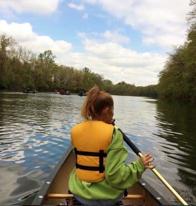 A person in a canoe on a river Description automatically generated